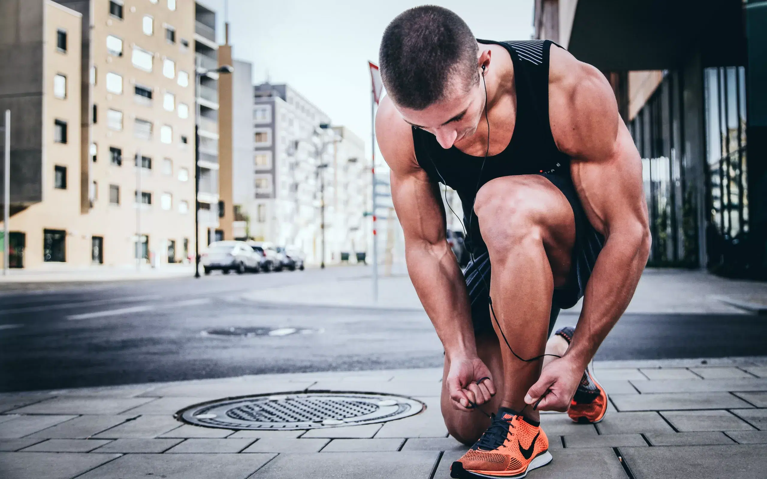 man with lean physique tying shoe laces