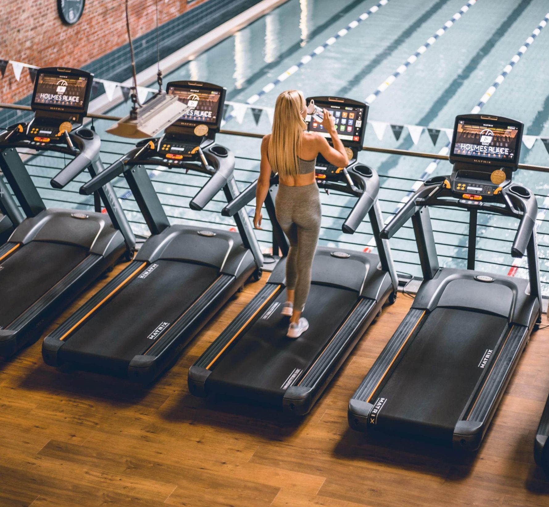 blonde woman on treadmill doing cardiovascular exercise in gym