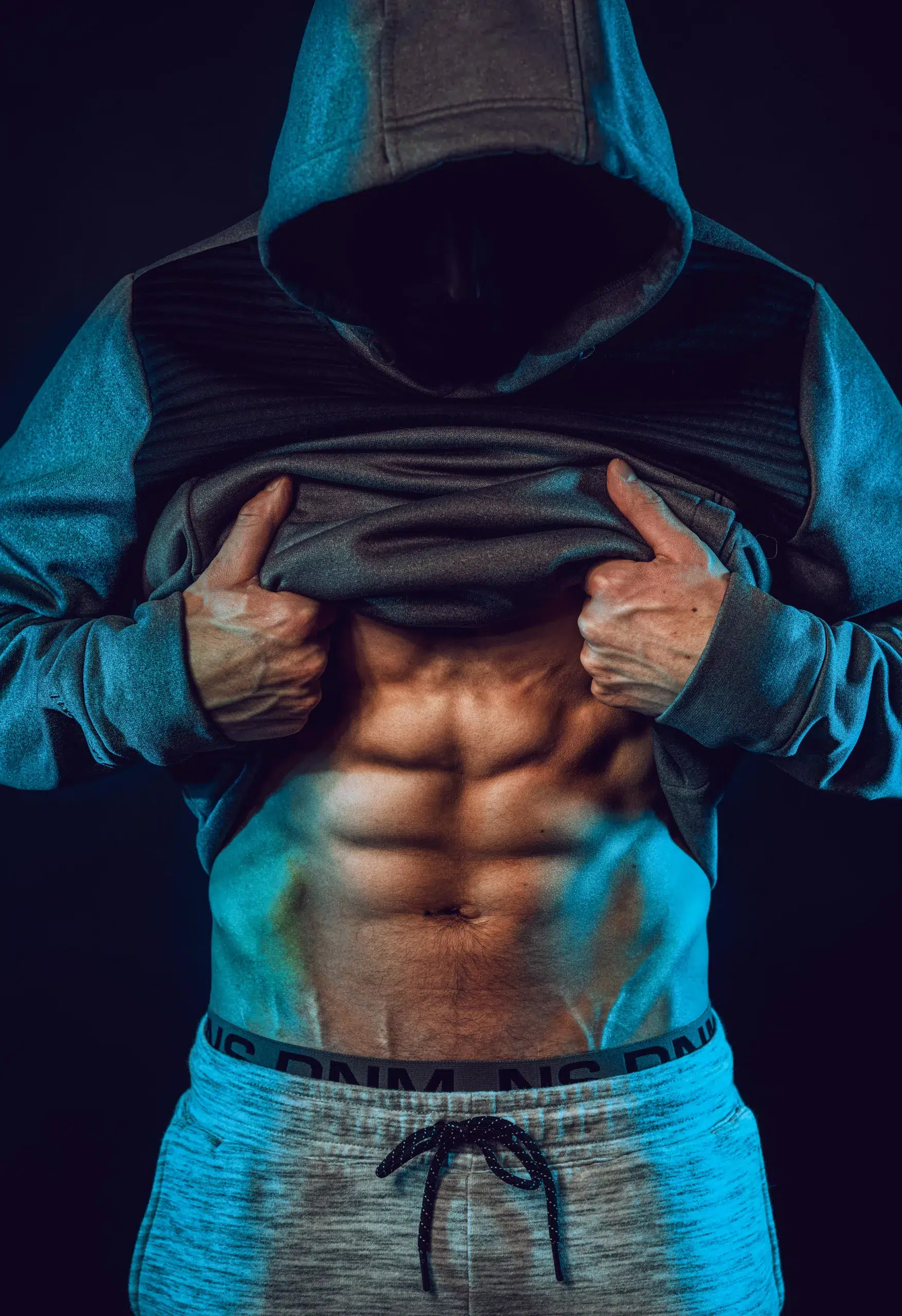 man showing his six pack abs in jumper