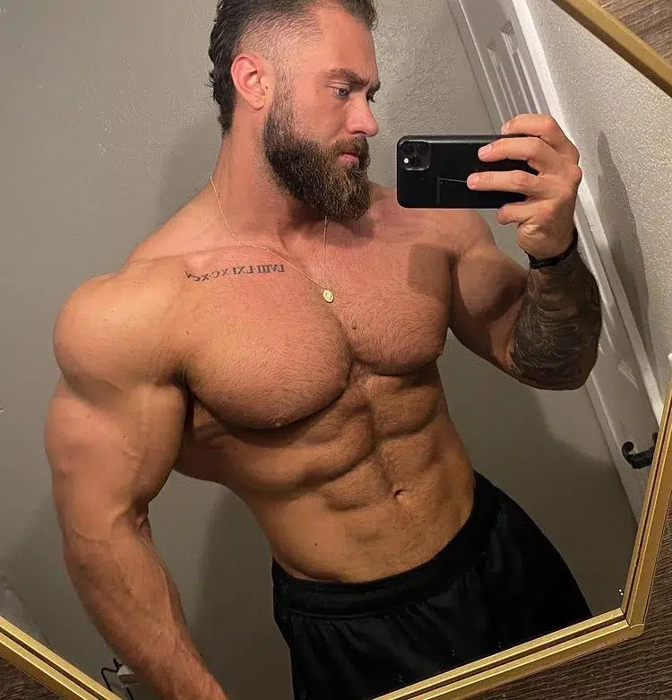 chris bumstead topless showing off lean and muscular bodybuilder physique