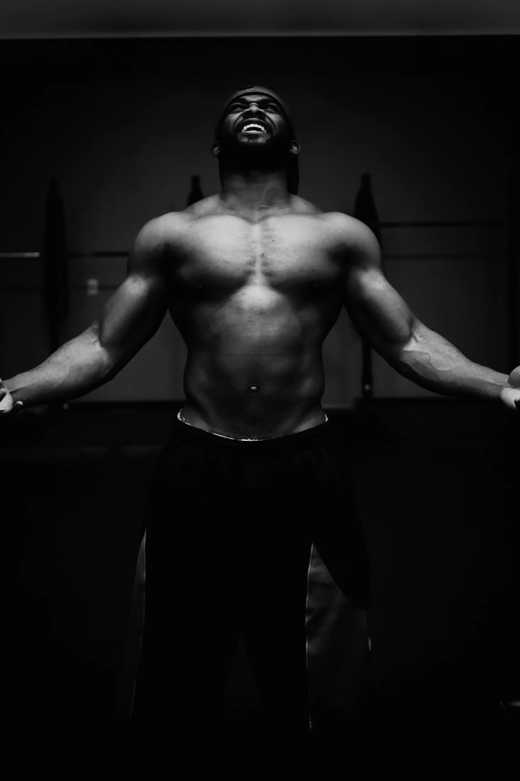 man with toned physique in black and white topless photo