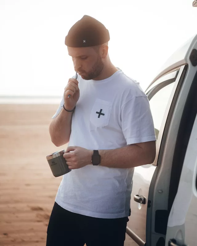 man brushing teeth outside